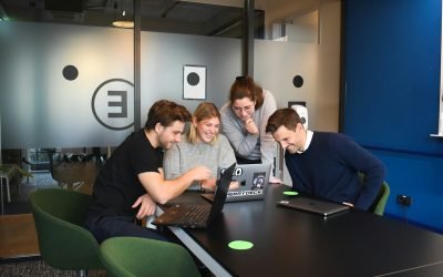 des gens assis sur une chaise devant des ordinateurs portables